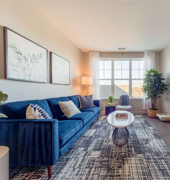 a living room with a blue couch at Heigts at Glen Mills at Heights at Glen Mills, Glen Mills, PA 19342