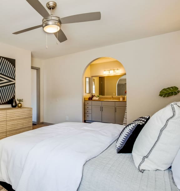a bedroom with a bed and a ceiling fan