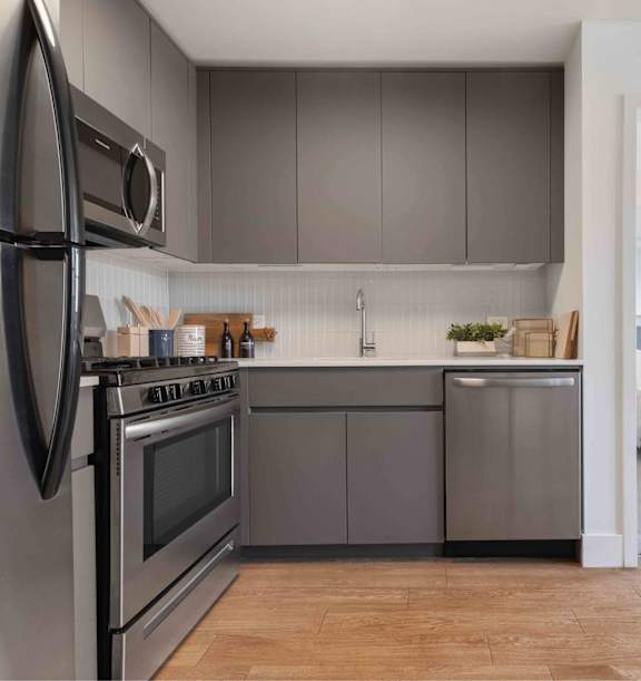 A modern kitchen with a stainless steel refrigerator and oven.