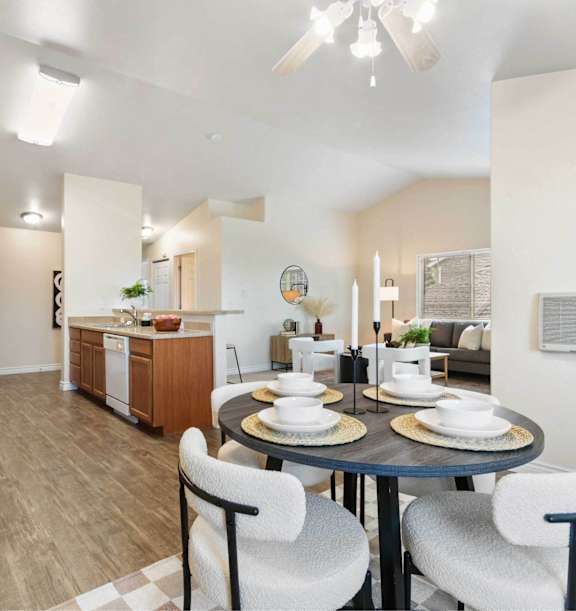 A modern kitchen with a dining table set for two.