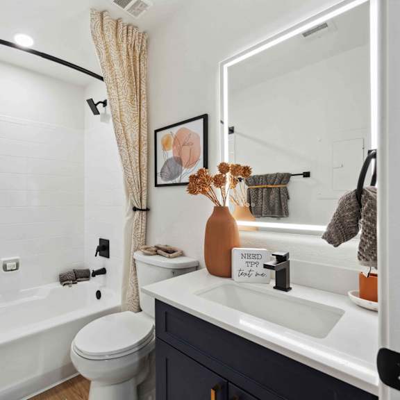 A bathroom with a white tub, sink, and toilet.
