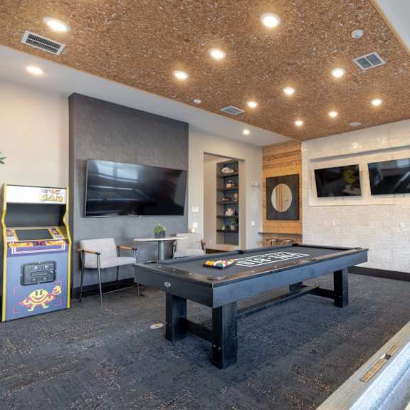 A room with a pool table and a foosball table.