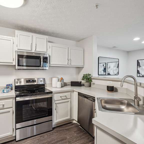 a kitchen with stainless steel appliances and white cabinets at Gwinnett Pointe in Georgia 30093