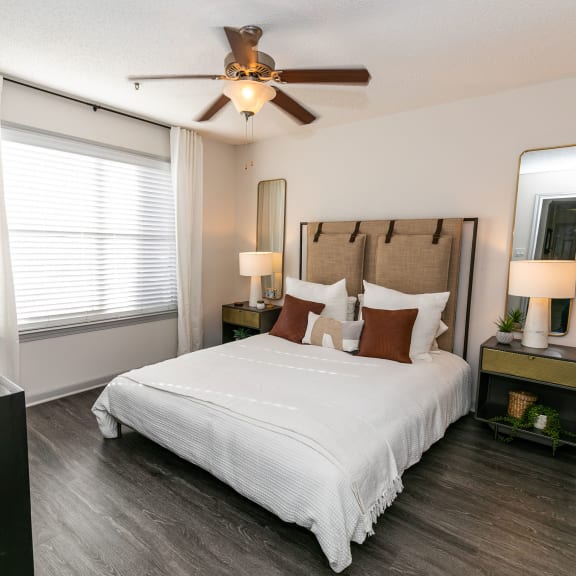 a bedroom with a large bed and a ceiling fan  at Briarcliff Apartments in North Druid Hills, 30329