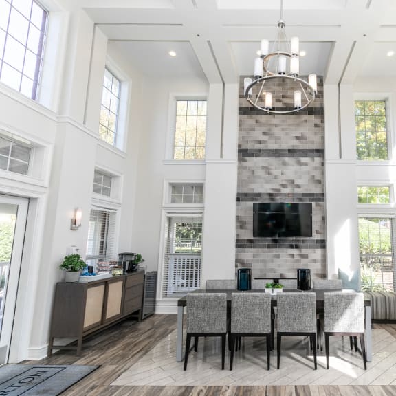 a living room with high ceilings and a large table and a fireplace at Roswell Village in GA 30075