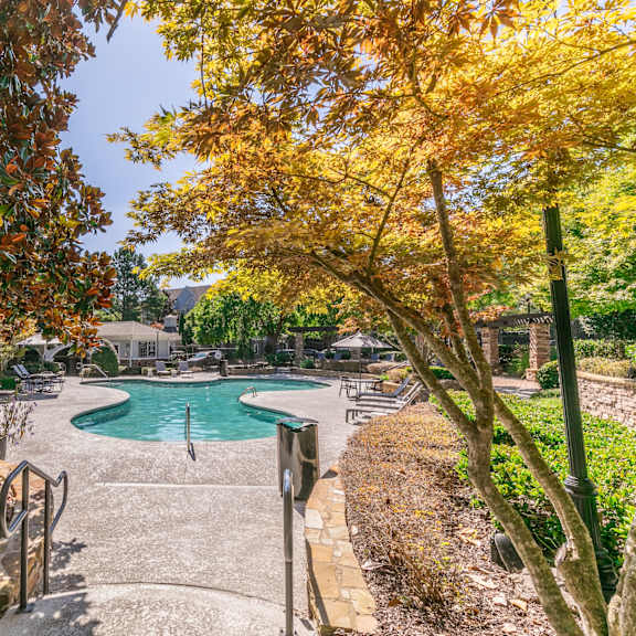 a swimming pool with trees and benches next to it at Deerfield Village, Alpharetta