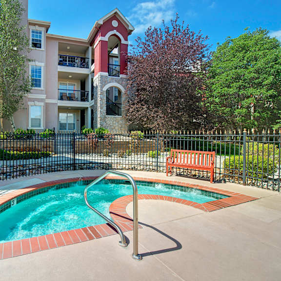 Camelback Pointe Resident Jacuzzi A hot tub with benches and an apartment building in the background at Camelback Pointe.