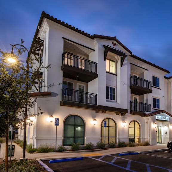 The front of the Mesa Vista Apartments building with a flag flying in the background.
