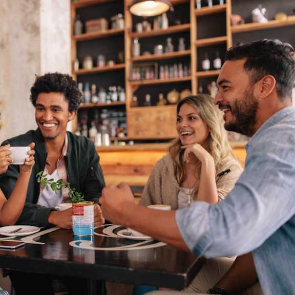 Four people are sitting around a table in a restaurant.