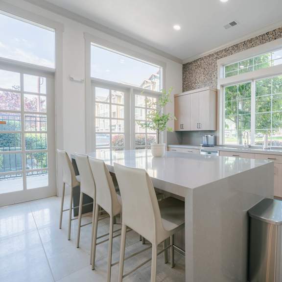 A kitchen with a large island and chairs.