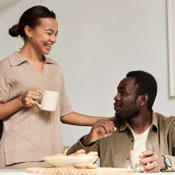 A woman serving a man a snack.