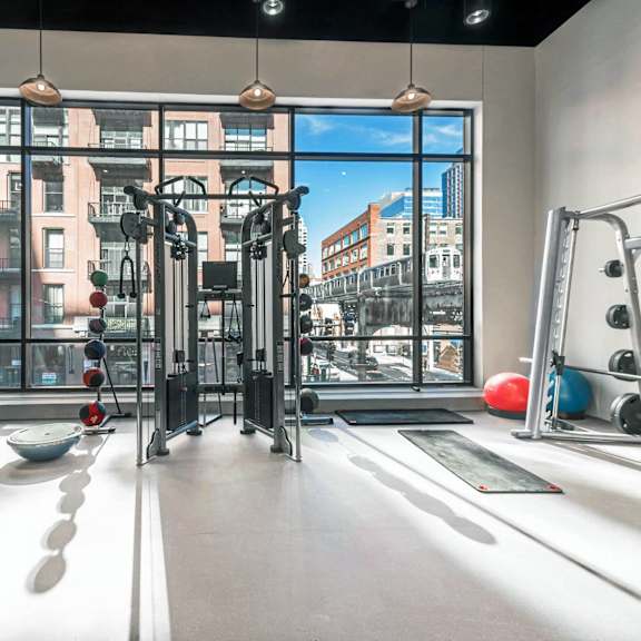 A gym with a view of the city outside the window.