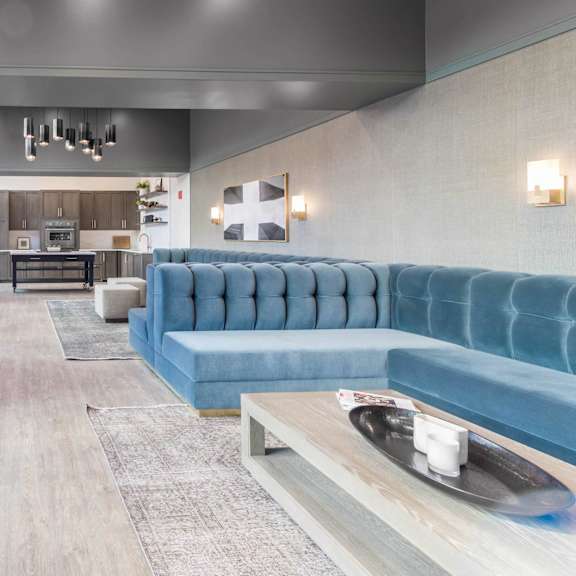 A modern living room with a blue couch and a television.