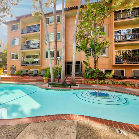 a large swimming pool in front of an apartment building