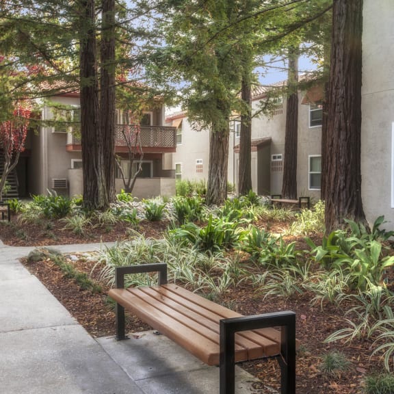 a wooden bench sitting in front of a building at Valley Plaza Villages, Pleasanton, 94566