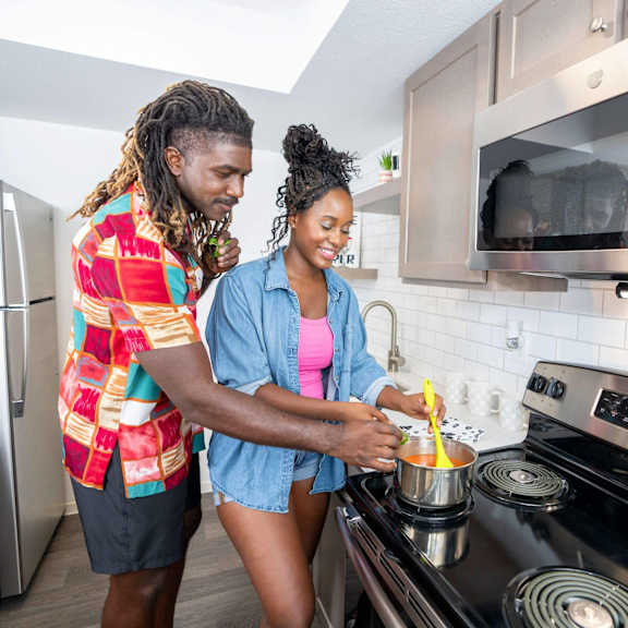Two people cooking in a modern kitchen.