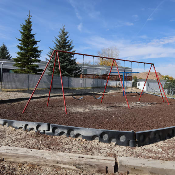a playground with a swing set and some dirt at Pioneer Park, Green River, Wyoming