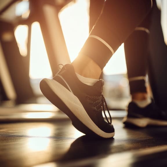 a woman walking on a treadmill with her shoes on