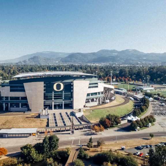 Autzen Stadium in Eugene, Oregon with mountains in the background