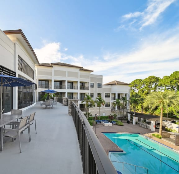 a patio with tables and chairs and a swimming pool