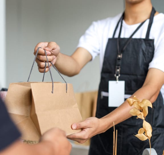 a person handing a paper bag to another person at The Quarry, Fort Collins, CO