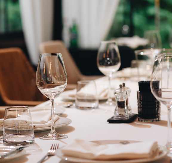 A table set for a meal with a glass of water in the foreground.