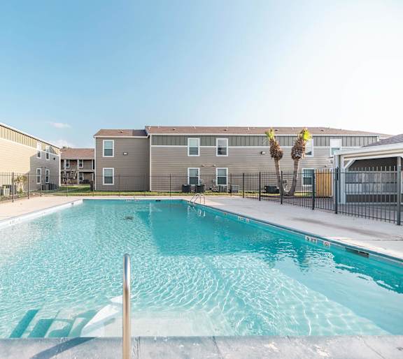 A pool in front of apartment buildings.