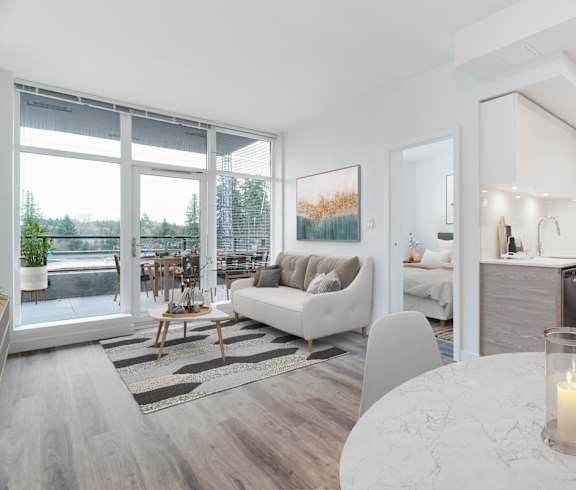 A modern living room with a white table and a lit candle on it.