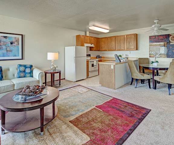 A living room with a kitchen and a dining room at Alpine Apartments. 