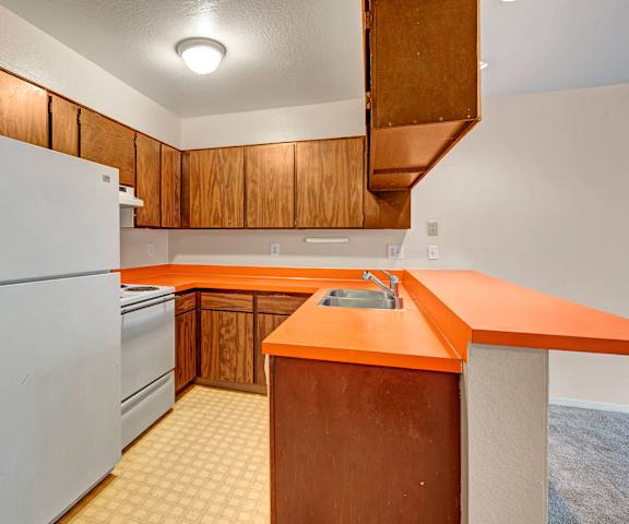 A kitchen with an orange counter top and a white refrigerator at Arbor Pointe Apartments. 
