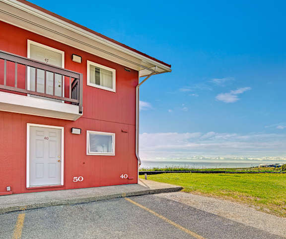 Red apartments with a view of the ocean at Bay Arms Apartments. 