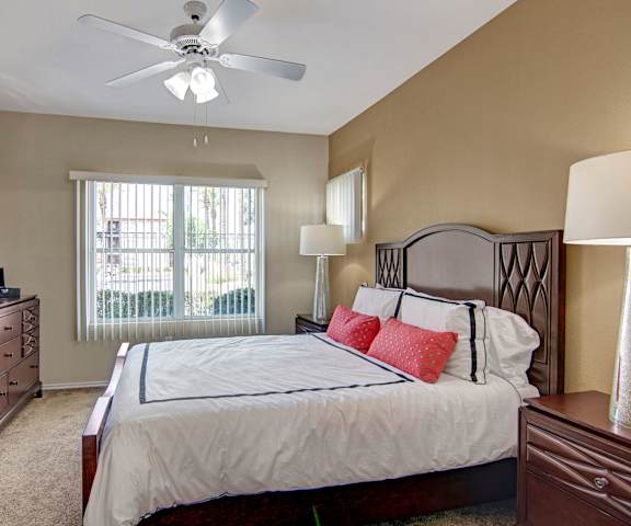 A bedroom with a queen-size bed, a dresser, decorations, window, and nightstands at Mozaic at Steele Park Apartments. 