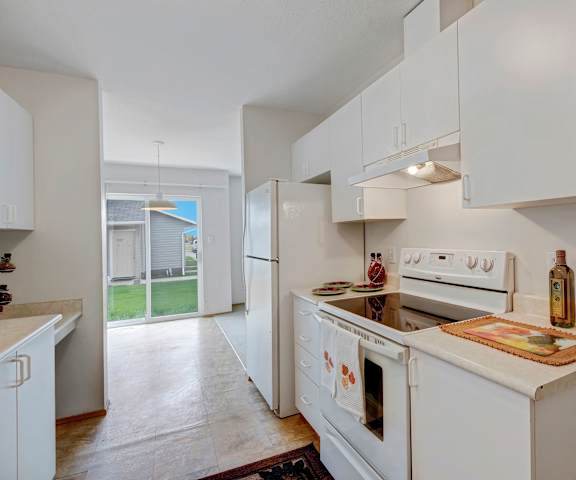 A kitchen with white appliances and counters at Carrington Place