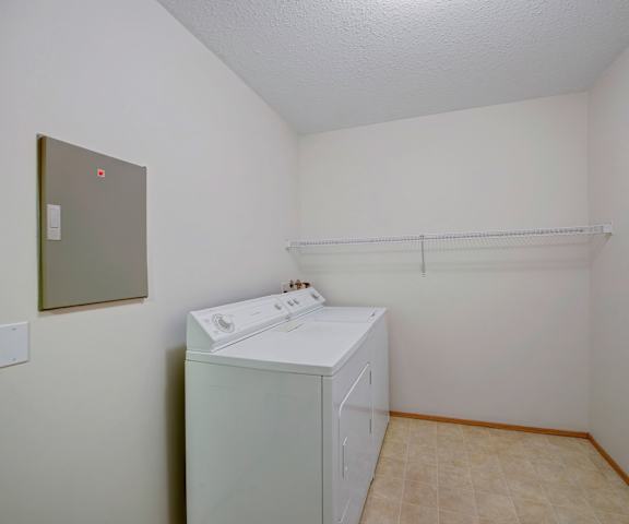 An empty laundry room with a washer and dryer in it at Carrington Place Apartments. 