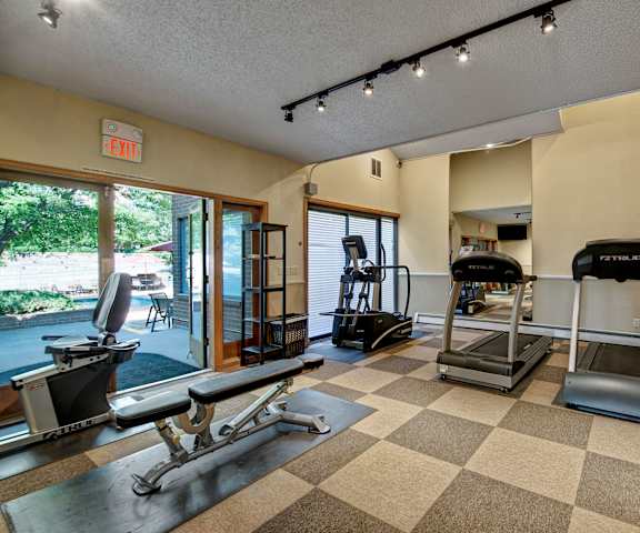 Eagle Ridge Fitness Center Equipment A gym with cardio machines, TVs, and weights at Eagle Ridge Apartments.