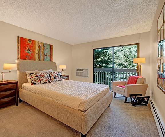 A bedroom with a queen-size bed, balcony, and nightstands at Eagle Ridge. 