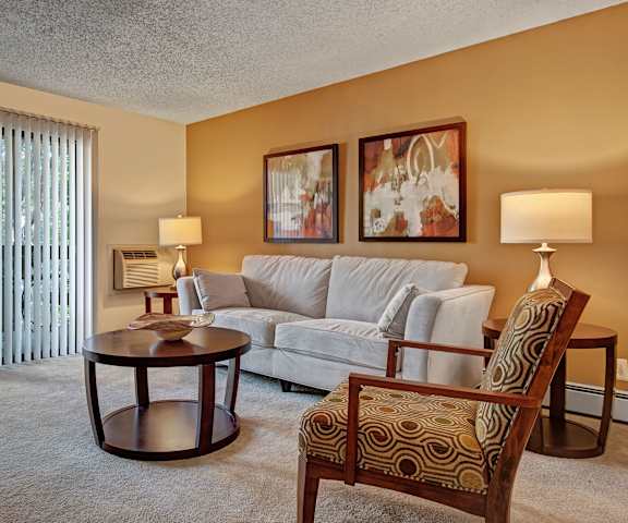 The living room with a couch, coffee table, decorations, a TV, and balcony at Eagle Ridge. 