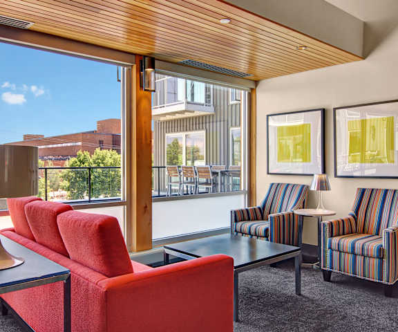 The resident lounge area in the clubhouse at 7West with a large window, plush chairs, and a couch. 