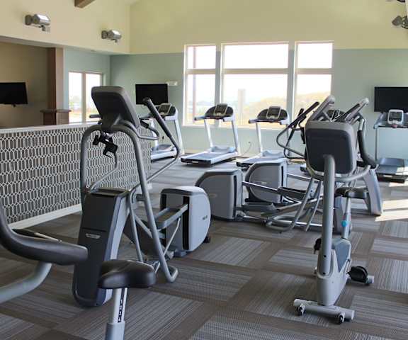24-Hour Fitness Center A gym with cardio machines, windows, TVs, and weights at Renaissance Heights Apartment Homes.