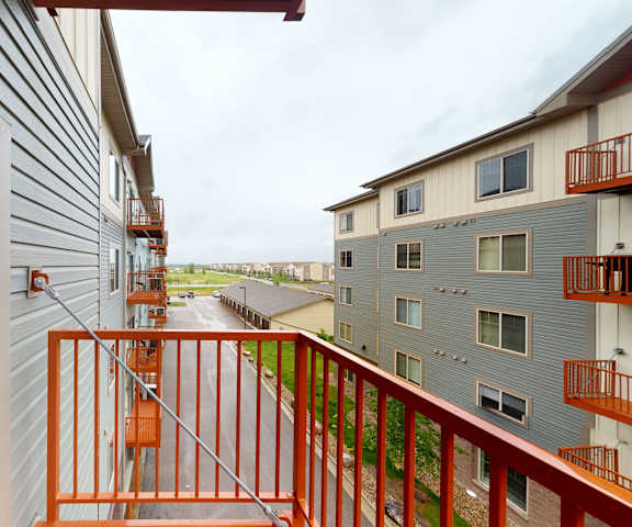 Renaissance Heights Balcony An orange balcony with a view of at the other apartment buildings, the other orange balconies, and the street at Renaissance Heights Apartment Homes.