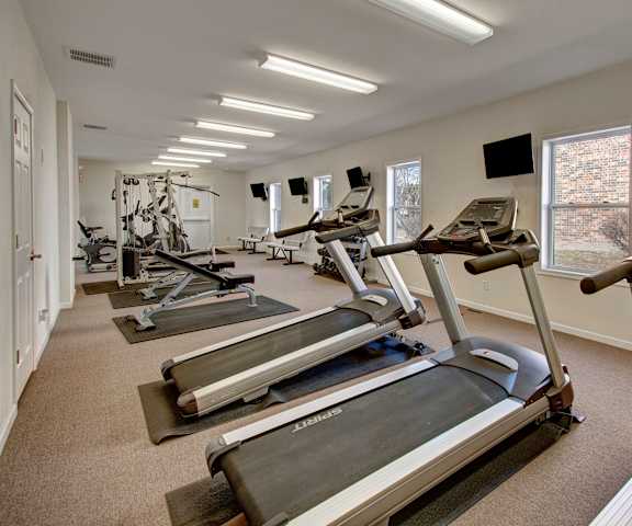 Windscape Gym A spacious gym with cardio machines, windows, TVs, and weights at Windscape Apartment Homes.