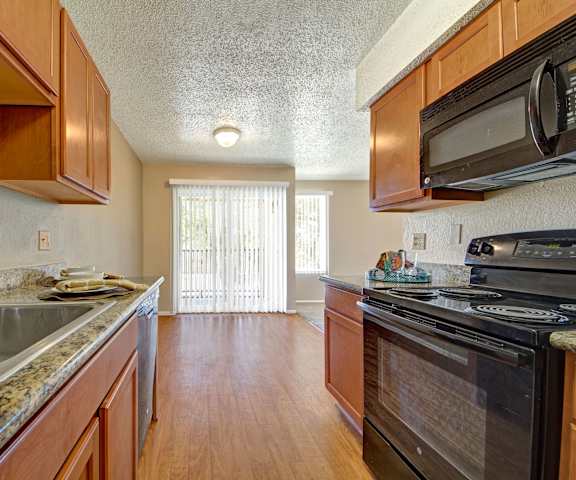 Avalon Springs kitchen with granite countertops, light cabinets, and black appliances. 