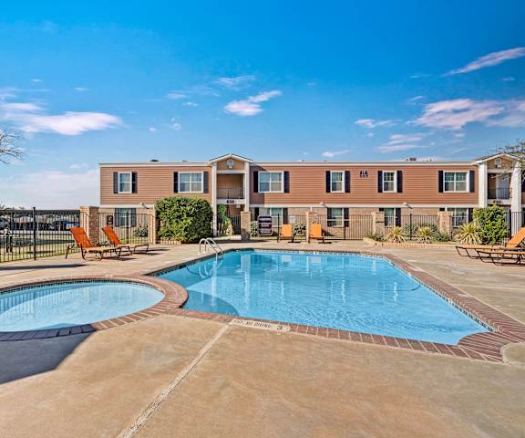 Golden Crest Outdoor Pool The light blue outdoor pool with a jacuzzi, pool chairs, tables, and chairs at Golden Crest.
