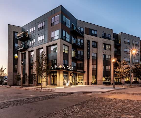 The black and gray exterior of the Vim and Vigor Lofts during the evening. 