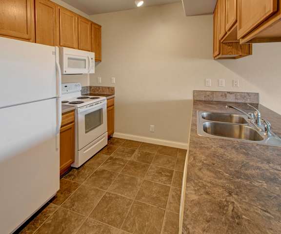 Confluence at Harvest Hills Kitchen A kitchen with white appliances and counters at Confluence at Harvest Hills.