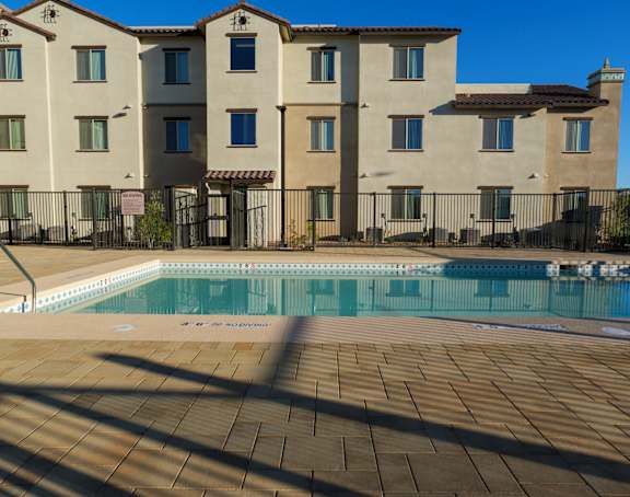 A large building with a pool in front of it.