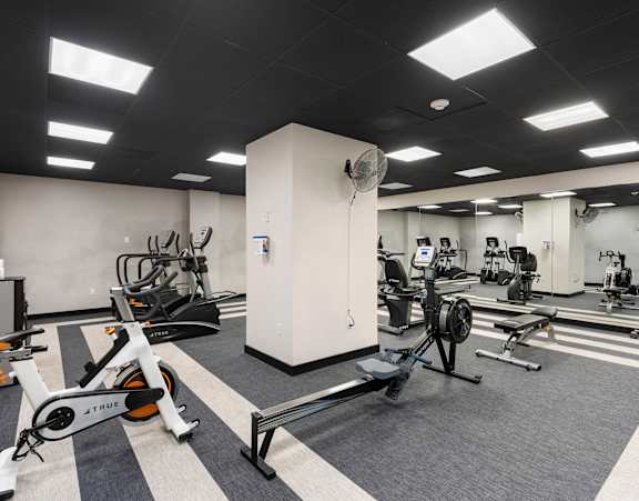 a gym with exercise equipment and weights in a building