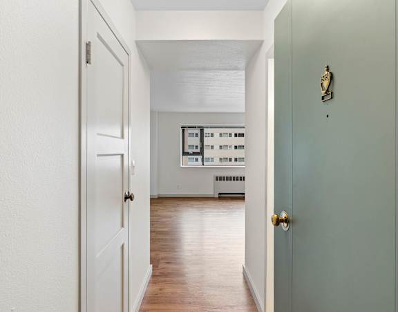an empty room with a door open to a living room
