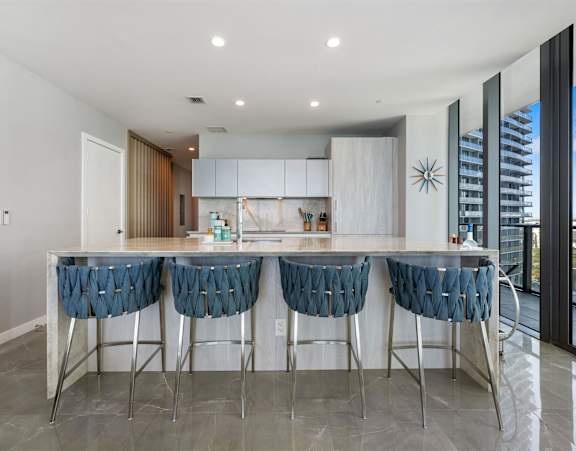 A modern kitchen with white countertops and a large island.