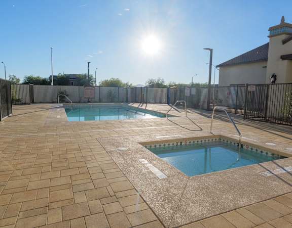 A sunny day at the pool with a fence surrounding the area.